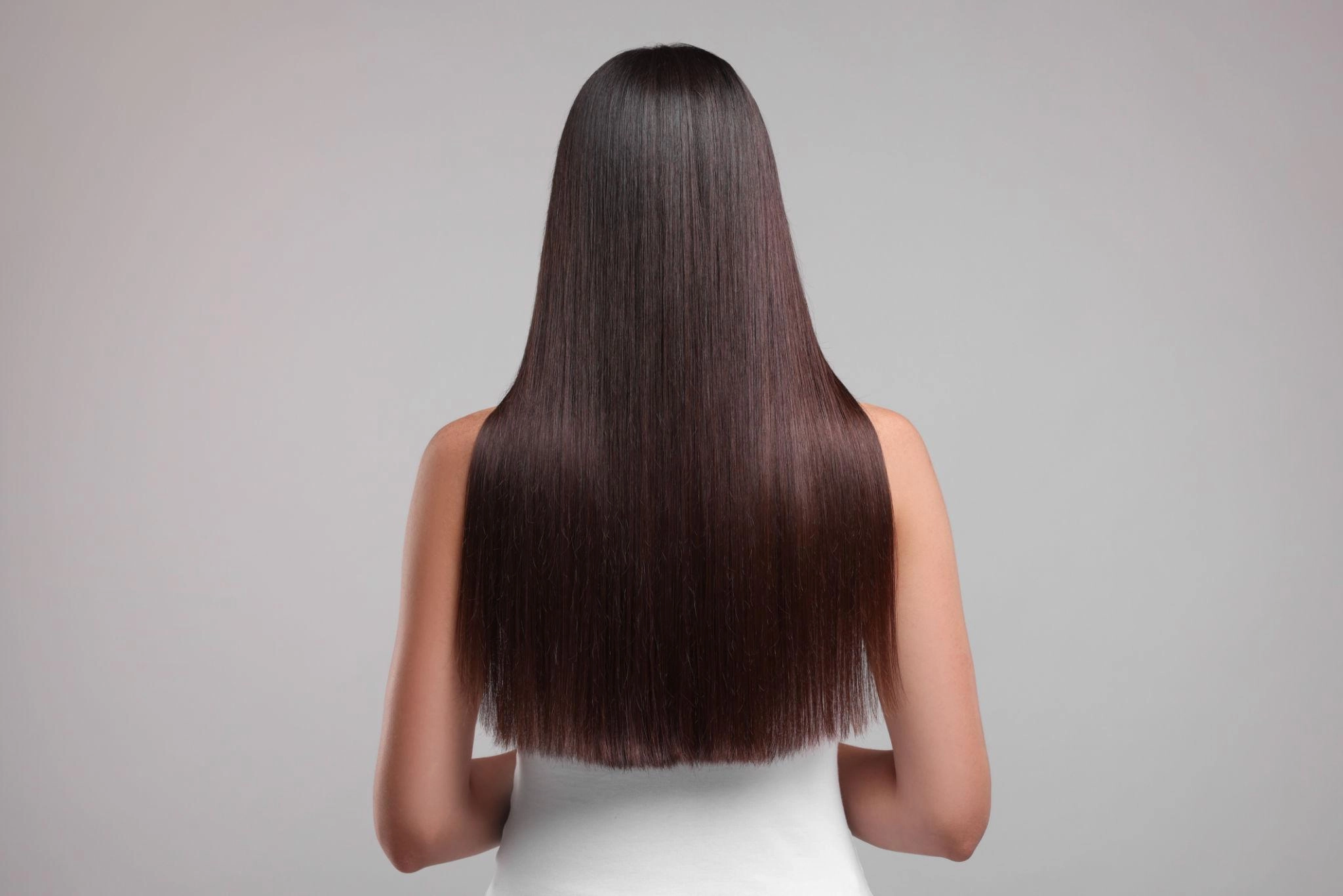 Cabelo longo, liso e brilhante após procedimento de alinhamento capilar.